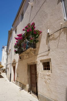 Balcony of a house in the old town of Rab in Croatia with many flowers as decoration