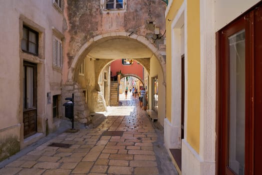 Alley in the historical old town of Rab in Croatia with tourists