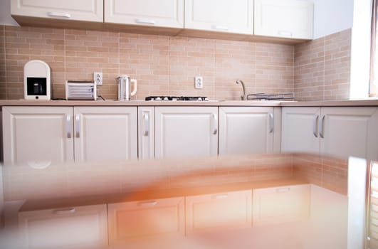 Blurred kitchen interior and white desk space. Home background