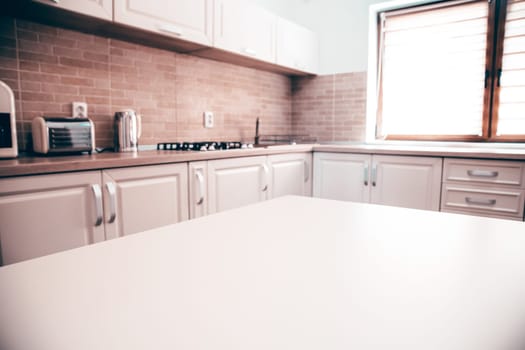 Blurred kitchen interior and white desk space. Home background