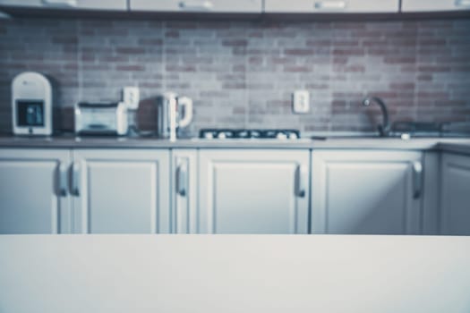 Blurred kitchen interior and white desk space. Home background