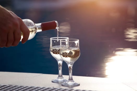 Summer party, wine in glasses near the swiming pool, summer drinks, relaxing by the water