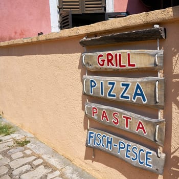 Advertisement for a typical restaurant in an alley in the old town of Krk in Croatia