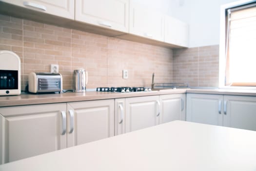 Blurred kitchen interior and white desk space. Home background