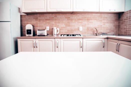 Blurred kitchen interior and white desk space. Home background