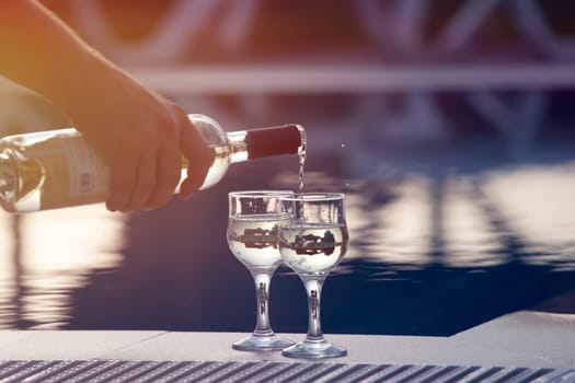 Summer party, wine in glasses near the swiming pool, summer drinks, relaxing by the water