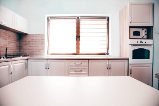 Blurred kitchen interior and white desk space. Home background