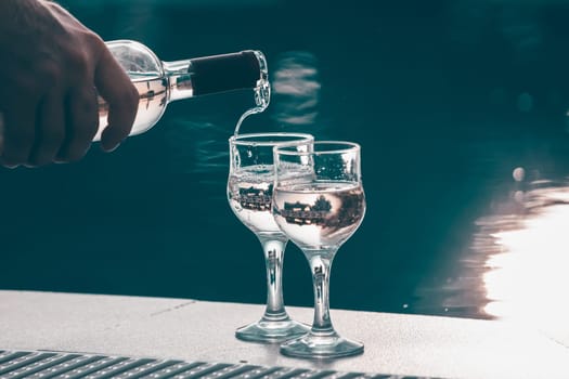 Summer party, wine in glasses near the swiming pool, summer drinks, relaxing by the water