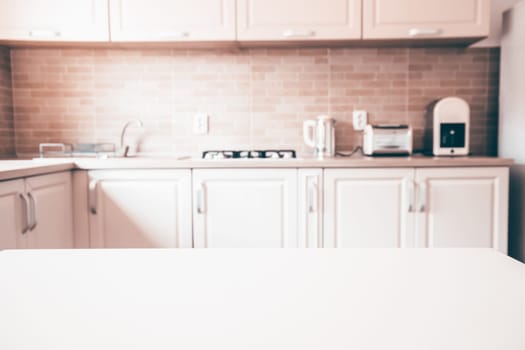 Blurred kitchen interior and white desk space. Home background