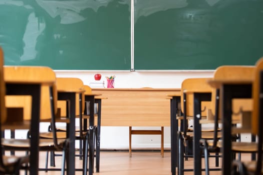 Back to School Concept. Empty classroom with chairs, desks and chalkboard.