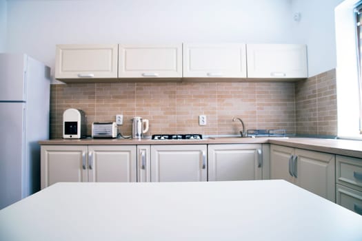 Blurred kitchen interior and white desk space. Home background