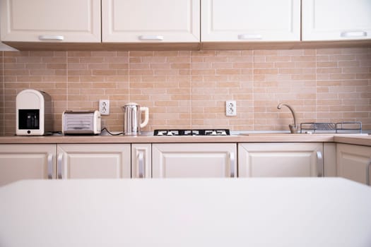 Blurred kitchen interior and white desk space. Home background
