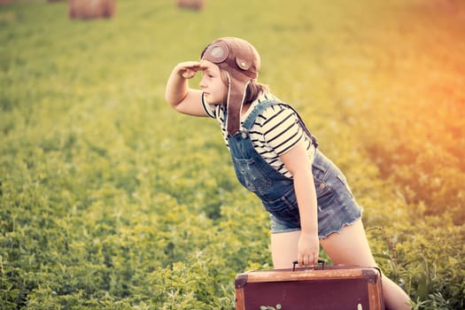 Happy kid playing in pilot helmet pretend to be aviator. Travel, vacation and freedom concept. Childhood, imagination, dream.