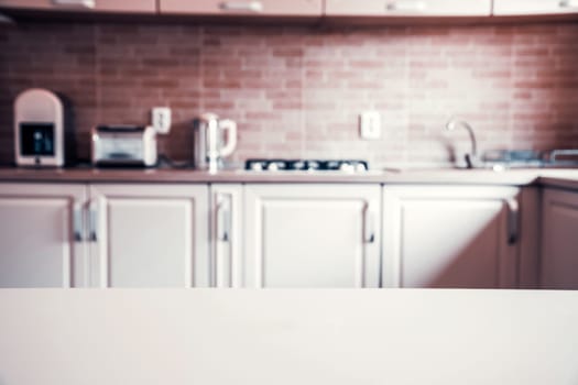 Blurred kitchen interior and white desk space. Home background