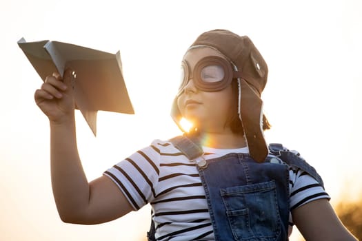 Happy kid playing in pilot helmet pretend to be aviator. Travel, vacation and freedom concept. Childhood, imagination, dream.
