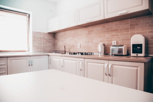 Blurred kitchen interior and white desk space. Home background