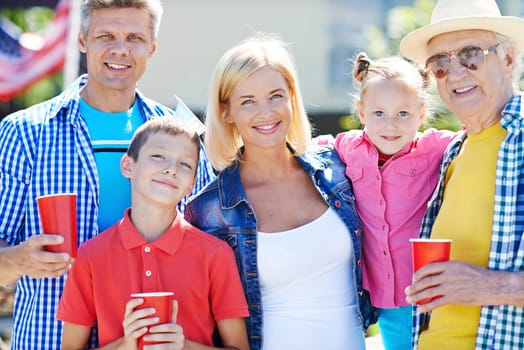Happy senior man with his children and grandchildren looking at camera