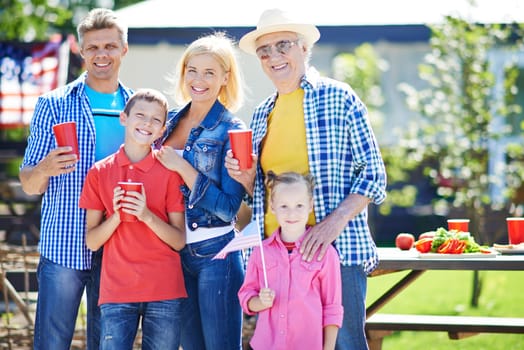 Happy senior man and young couple with two kids spending weekend outdoors