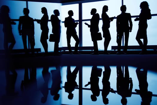Interacting business partners standing by window
