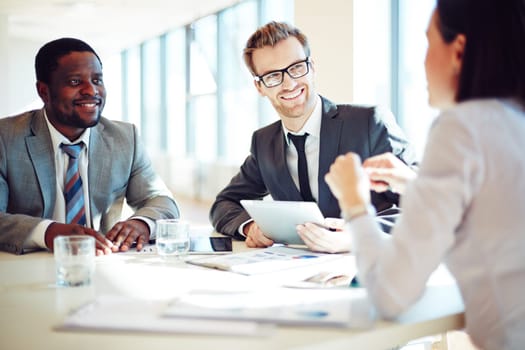 Smiling colleagues discussing working ideas in office