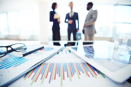 Business documents and touchpad with charts on desk