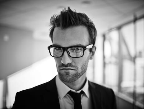 Elegant businessman in eyeglasses and formalwear looking at camera