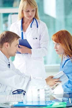 Young doctor in uniform measuring pressure of female