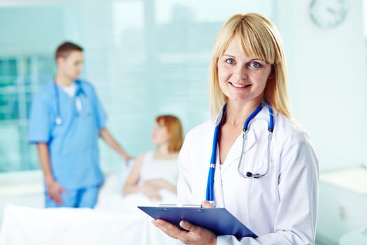 Pretty doctor in white coat looking at camera