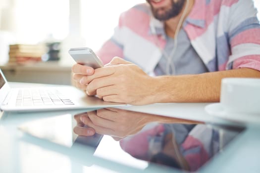 Modern gadgets on workplace and male hands with smartphone