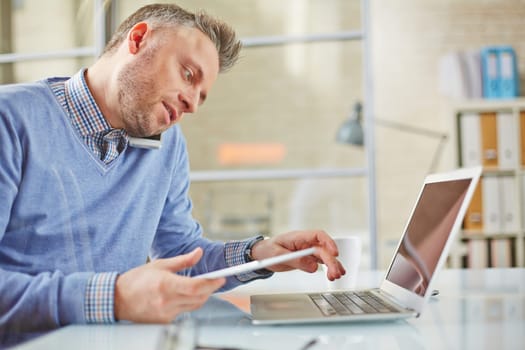 Young businessman or agent typing and speaking on cellphone