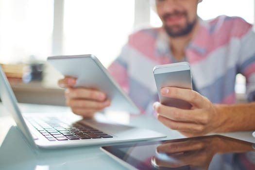 Modern gadgets for communication in male hands and on desk