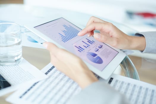 Economic analysis in touchpad and hand of businesswoman pointing at chart