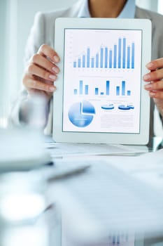 Businesswoman holding touchpad with charts and diagrams