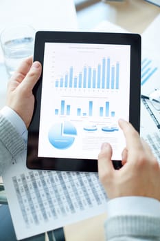 Market analysis or economic statistics in touchpad during business presentation
