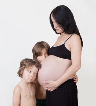 a woman with baby belly and two young children waiting for the birth
