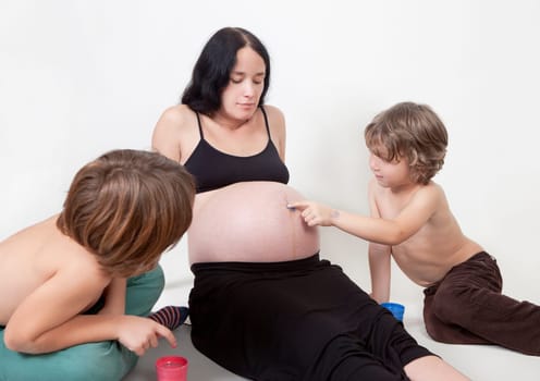 a woman with baby belly and two young children waiting for the birth