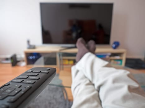 Man with remote control in front of the TV