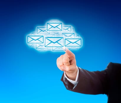 Forearm in blue corporate suit is reaching out to touch a swarm of emails in the shape of a cloud. Business or technology metaphor for mobile computing and instant information access. Copy space..
