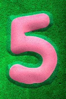 The number five in a pink sponge like texture, raised 3D from the green background.