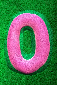 The number zero in a pink sponge like texture, raised 3D from the green background.