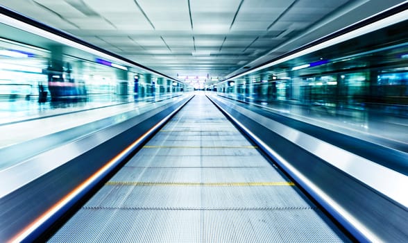 symmetric moving blue escalator inside contemporary airport, hong kong