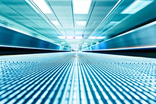 symmetric moving blue escalator inside contemporary airport, hong kong