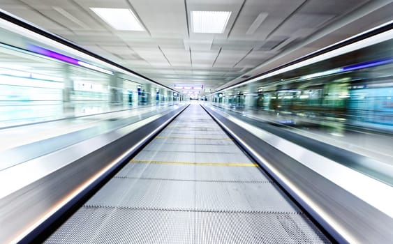 symmetric moving blue escalator inside contemporary airport