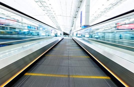 symmetric moving blue escalator inside contemporary airport, hong kong