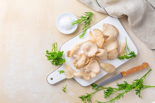 Organic oyster mushrooms with herbs and salt on cutting board