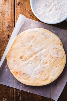 Flatbread, pita or pizza crust on wooden kitchen table
