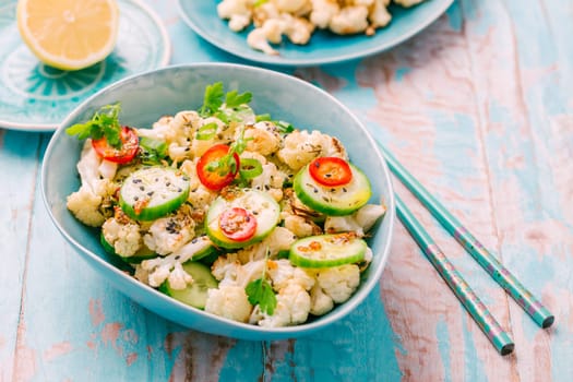 Asian salad with roasted cauliflower, cucumber, onion and chili