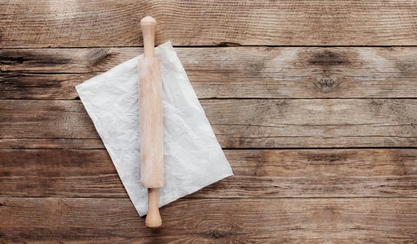 Ingredients for baking and kitchen utensils on old wooden background. Cooking baking dough, preparing flour, rocking pin, parchment paper. Baking concept flat lay photo with copy space