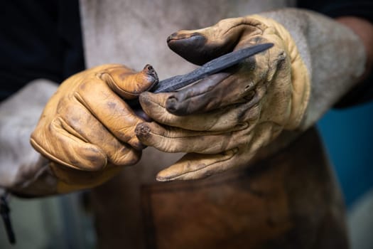 two man hands are manufacturing a steel knife