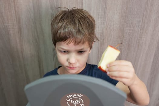 Child boy throwing apple core to waste bin for organic at home. Education about Waste Segregation concept